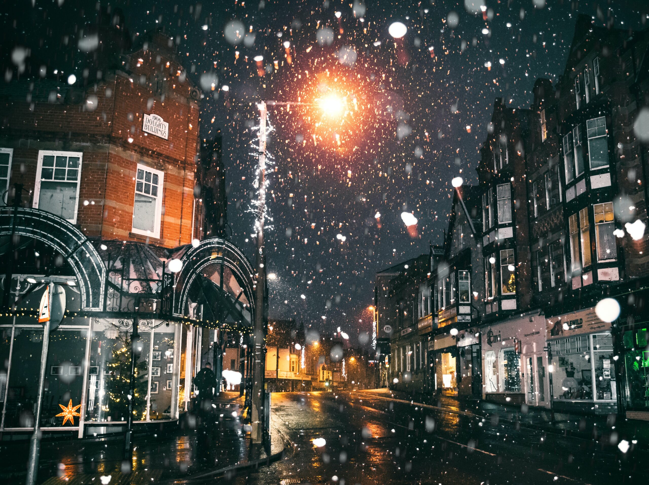 snow falling on a street during christmas